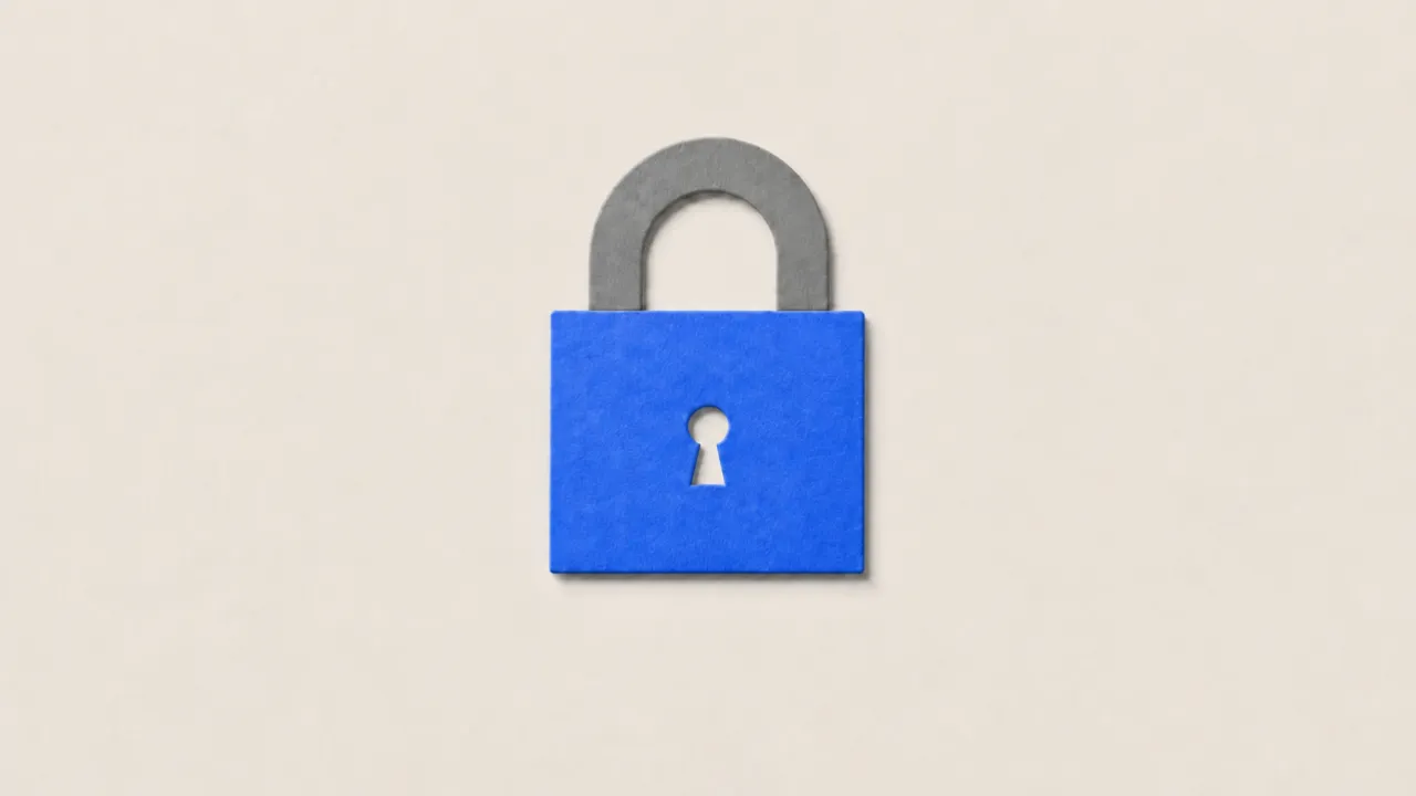 A paper cutout padlock in blue with a grey shackle on cream paper